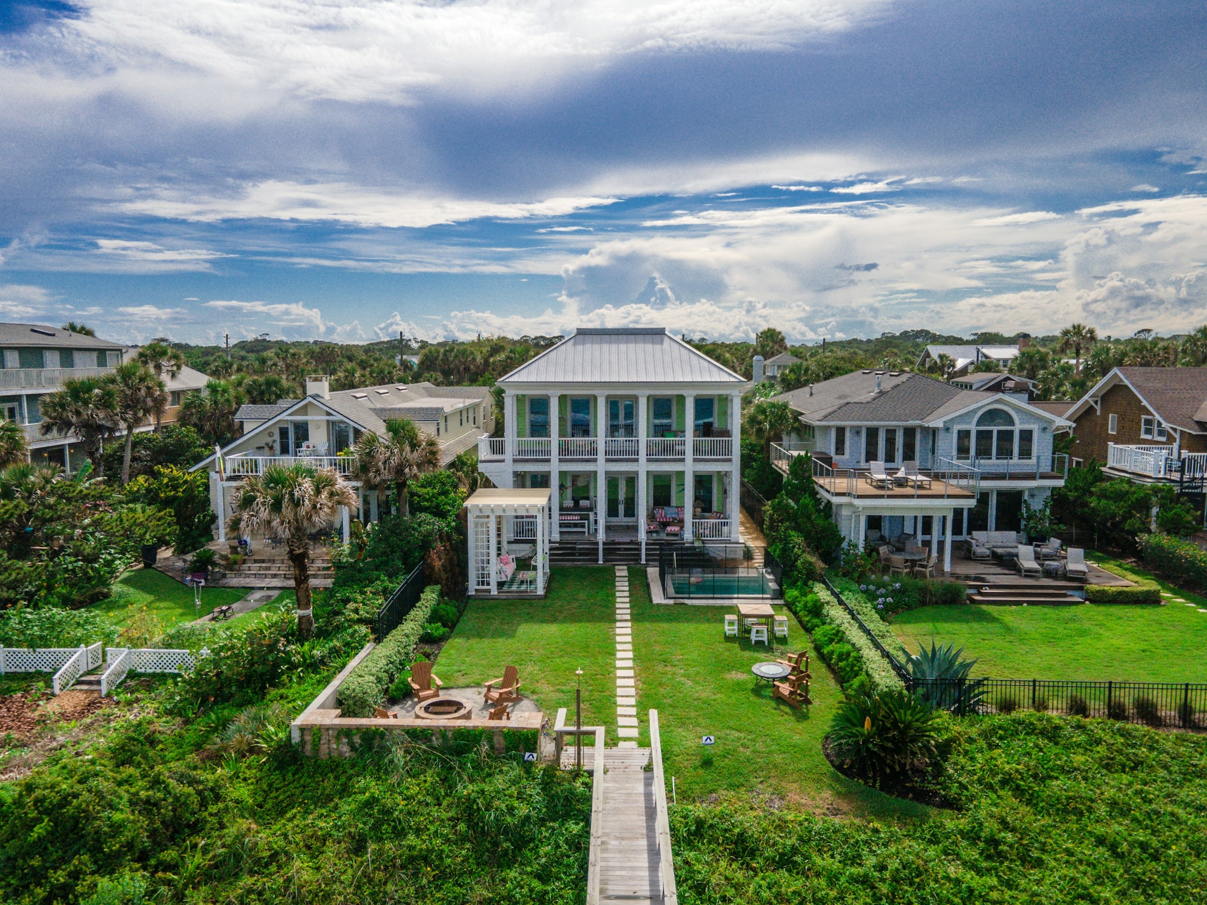 A luxury beachfront home with tall windows, palms and a private beach walkway in Atlantic Beach, Florida. Illustrative architecture, not a current listing.