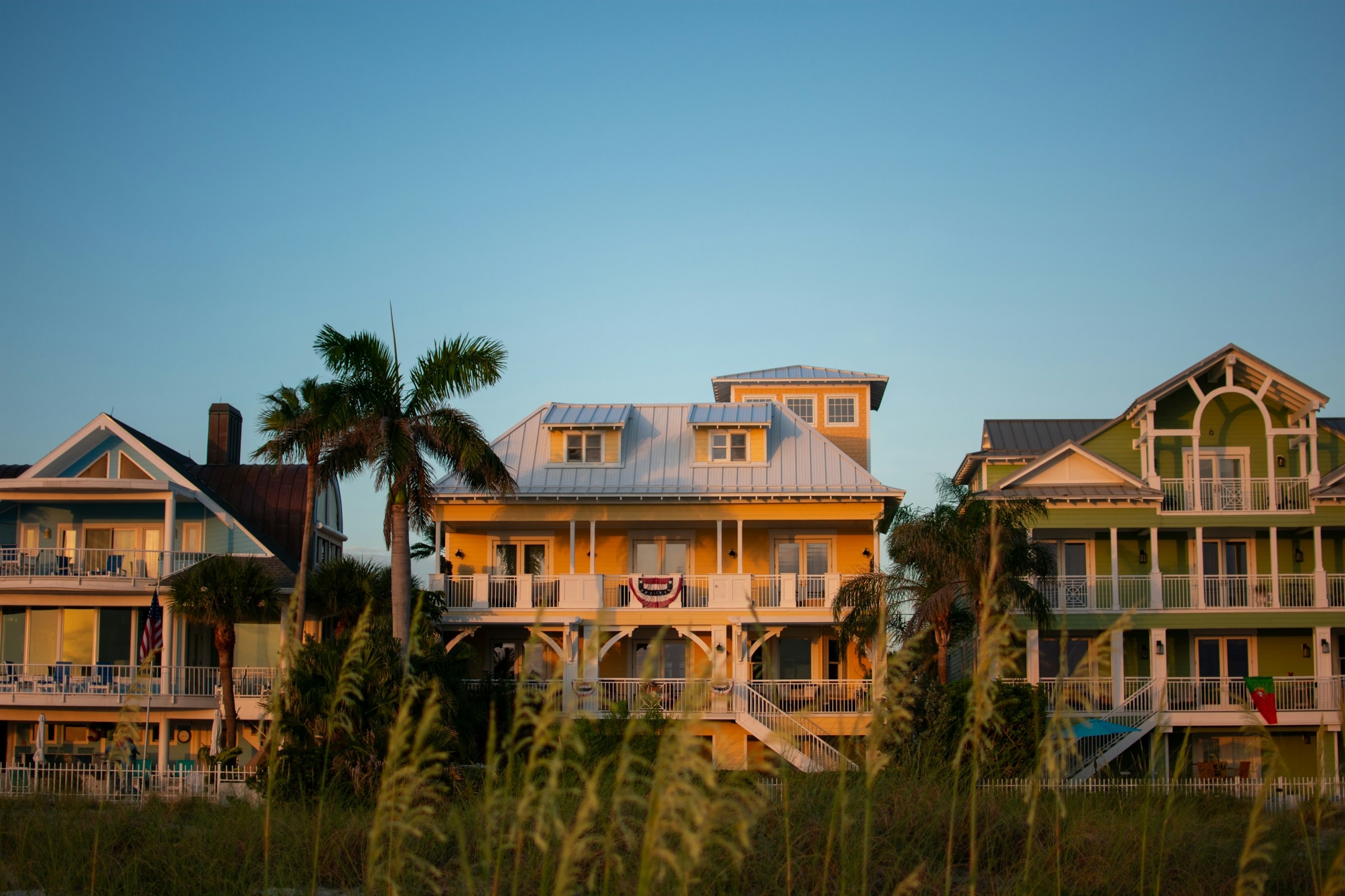 Large coastal homes and palms in the evening light in Clearwater, Florida. Illustrative architecture, not a current listing.